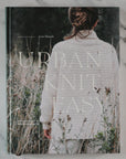 Book titled 'The Urban Knit Easy' with a person wearing a knitted garment on a marble surface.