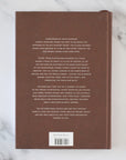 Brown book with text on a marble surface