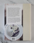 Book cover with a photograph of a dish and text on a marble surface