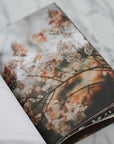 Open book with a floral page on a marble surface