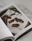 Open book showing a photograph of food on a marble surface