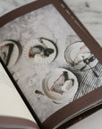 Open book with images of desserts on a marble surface