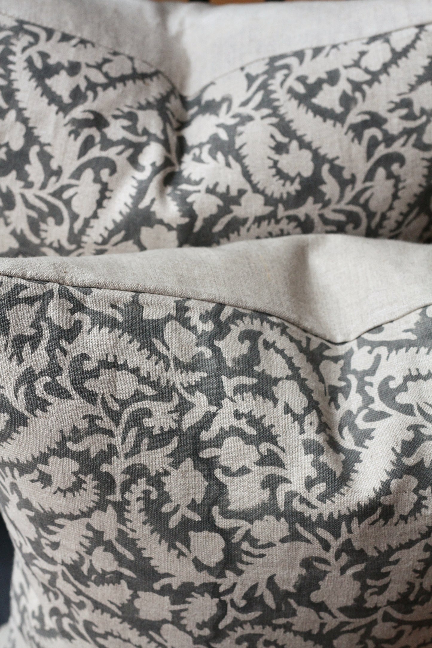 grey floral block printed cushion cover with a natrural colour background, linen. 45cm x 45cm.
