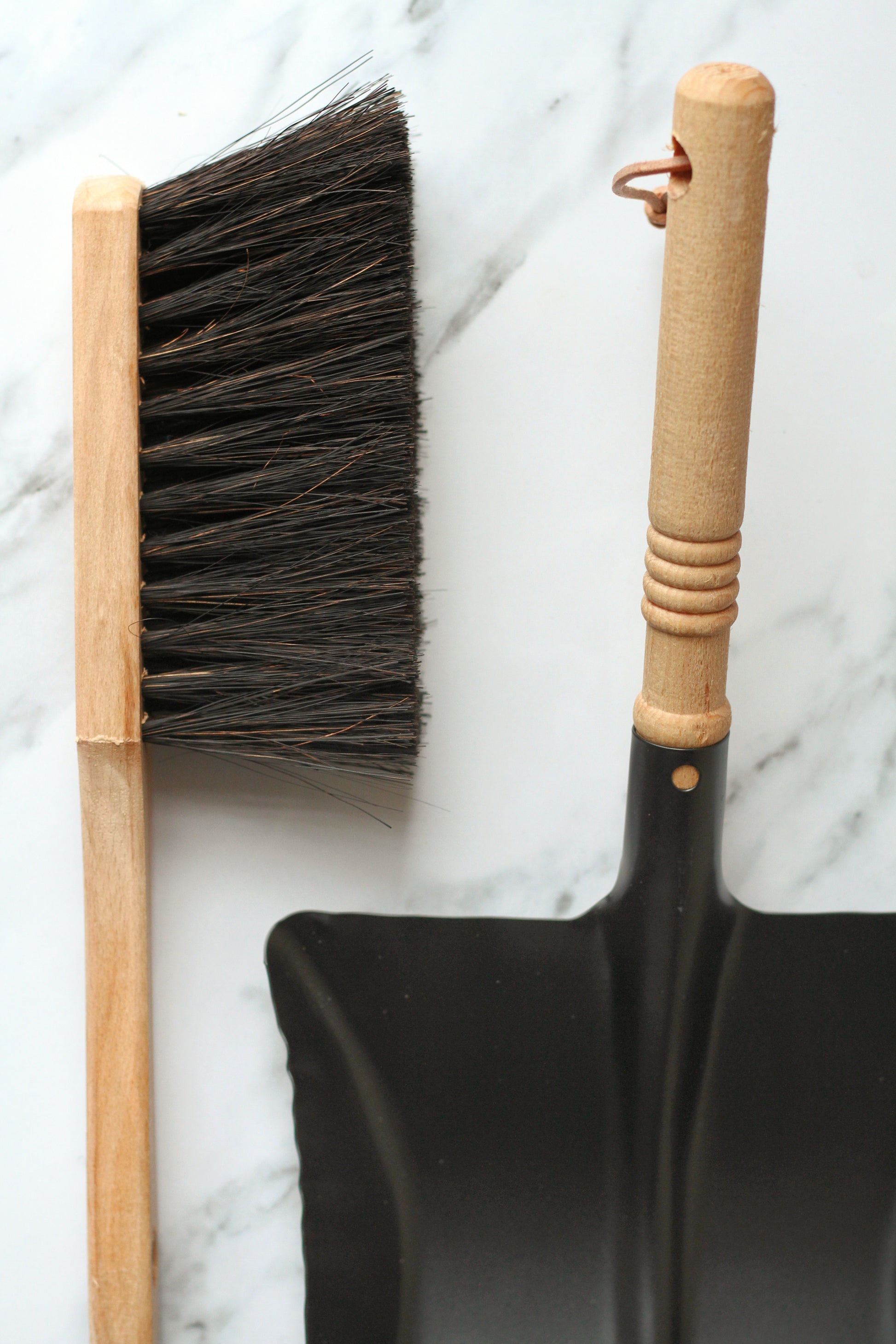 black metal dustpan with wooden handle  and wooden brush