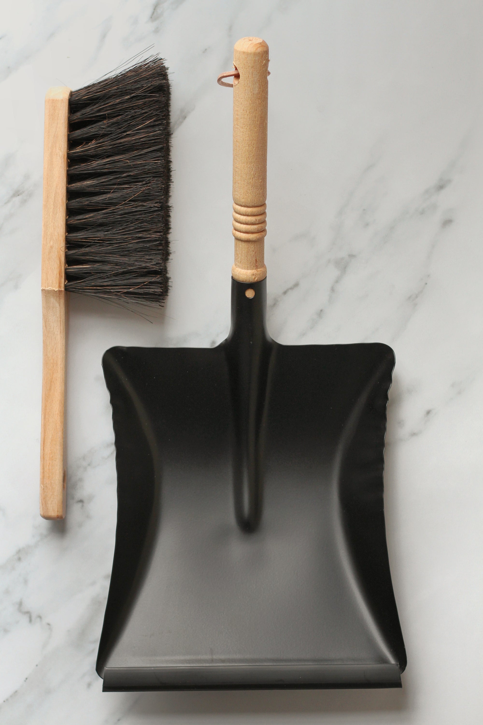 black metal dustpan with wooden handle  and wooden brush