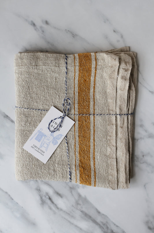 rustic table runner in a beige linen with a mustard stripe 