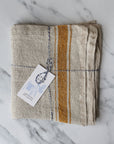 rustic table runner in a beige linen with a mustard stripe