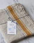 rustic table runner in a beige linen with a mustard stripe
