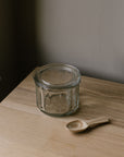 glass salt pot with lid and wooden spoon
