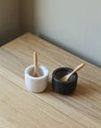 pair of marble salt and pepper pots with wooden spoons