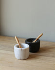 pair of marble salt and pepper pots with wooden spoons