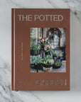 Book titled 'The Potted Garden' on a marble surface