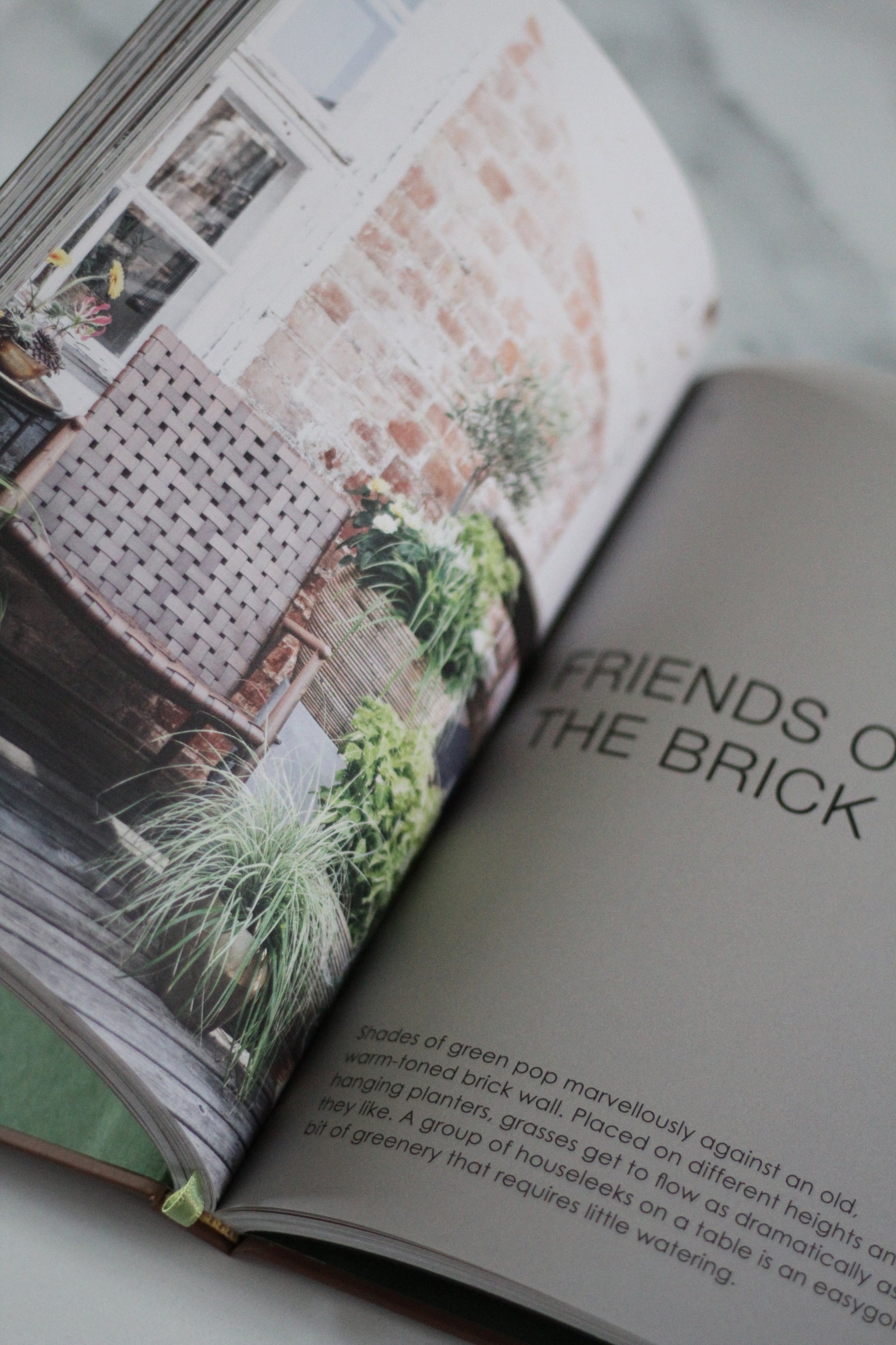 Open book with a page titled &#39;Friends of the Brick&#39; and images of plants and architecture.