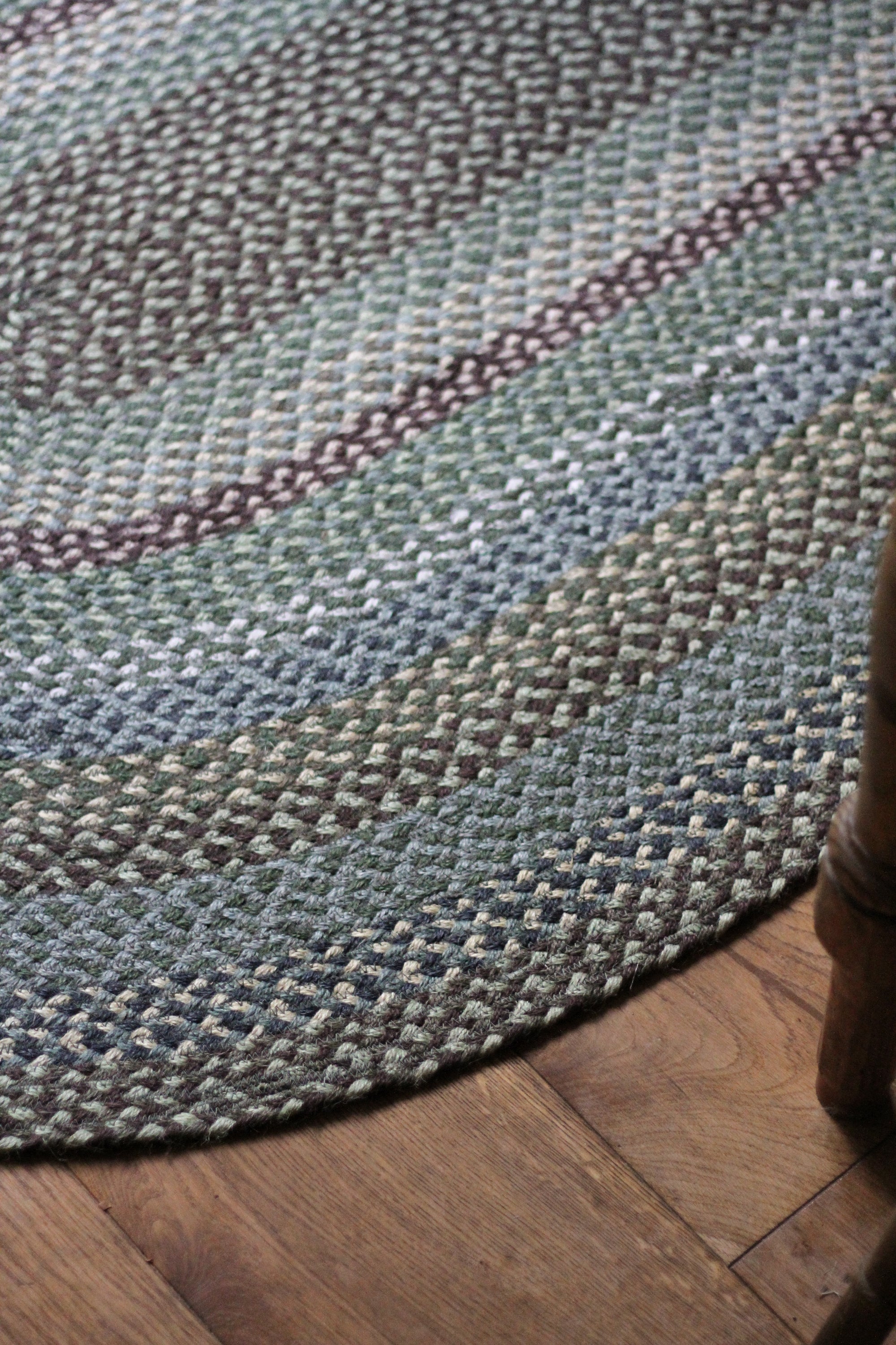 Braided jute rug in an oval shape in shades of green 