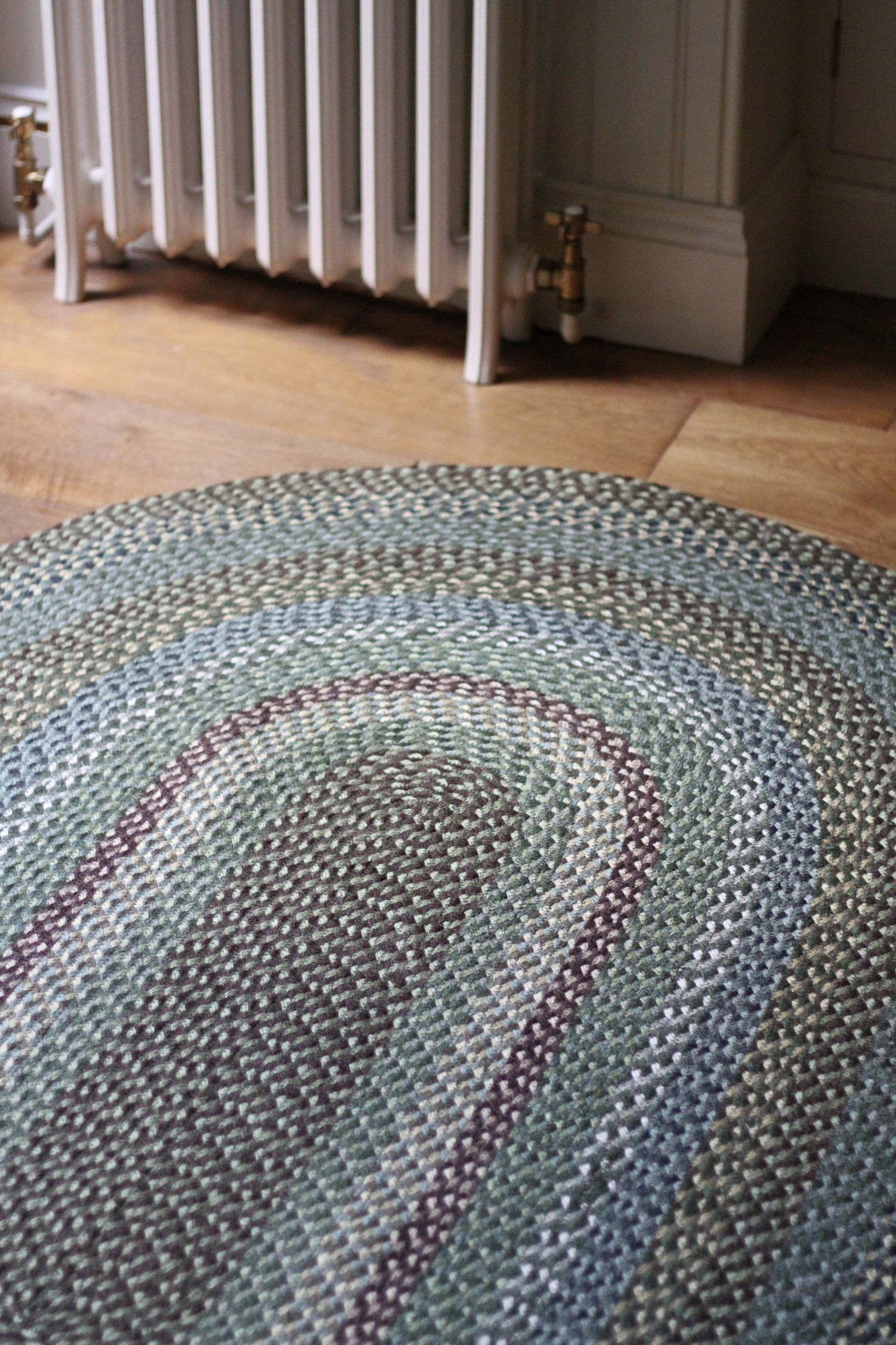 Braided jute rug in an oval shape in shades of green 