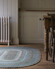 Braided jute rug in an oval shape in shades of green 