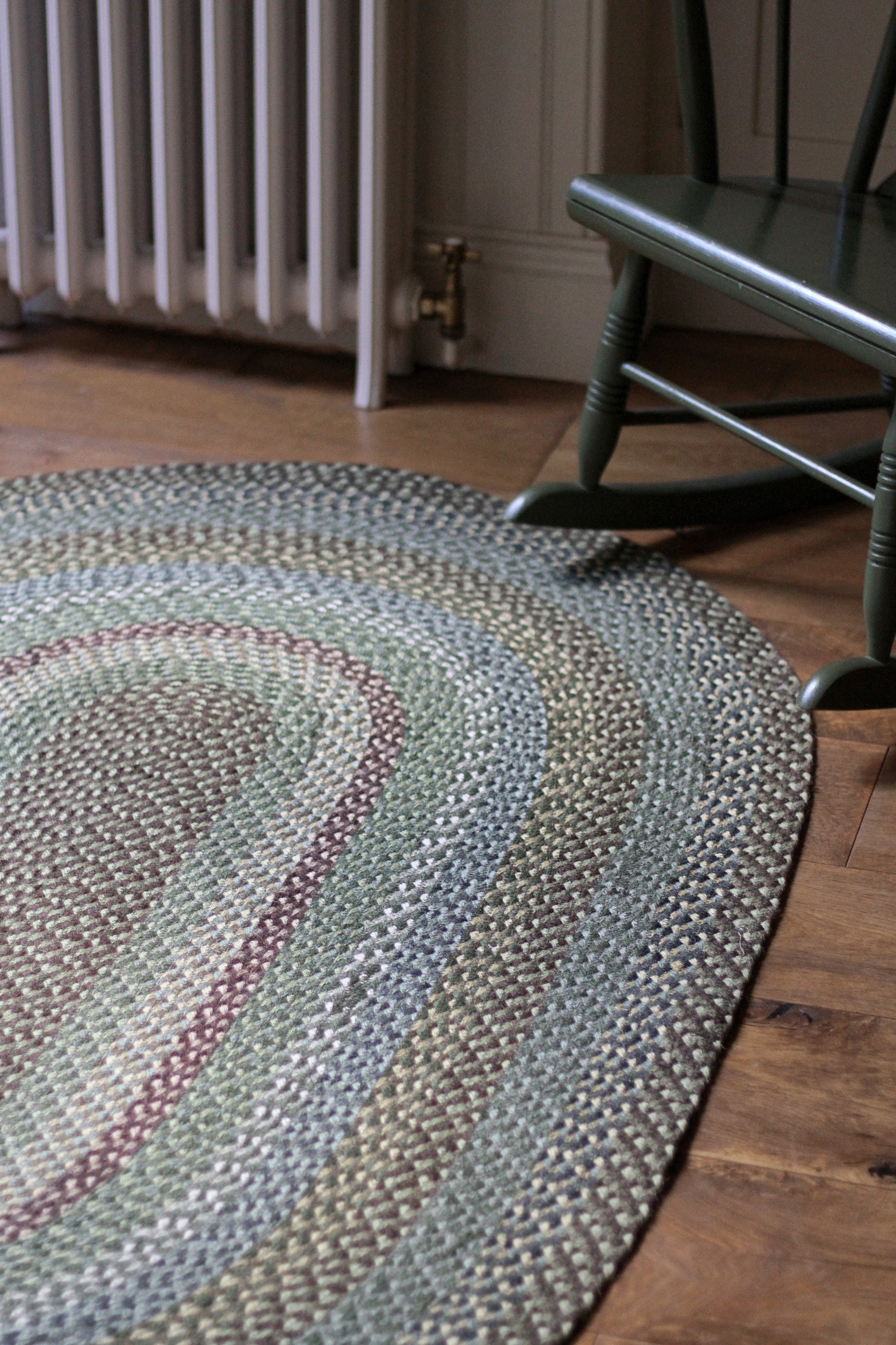 Braided jute rug in an oval shape in shades of green 