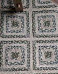 braided jute rug in a square patchwork design in shades of green