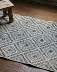 braided jute rug in a square patchwork design in shades of green