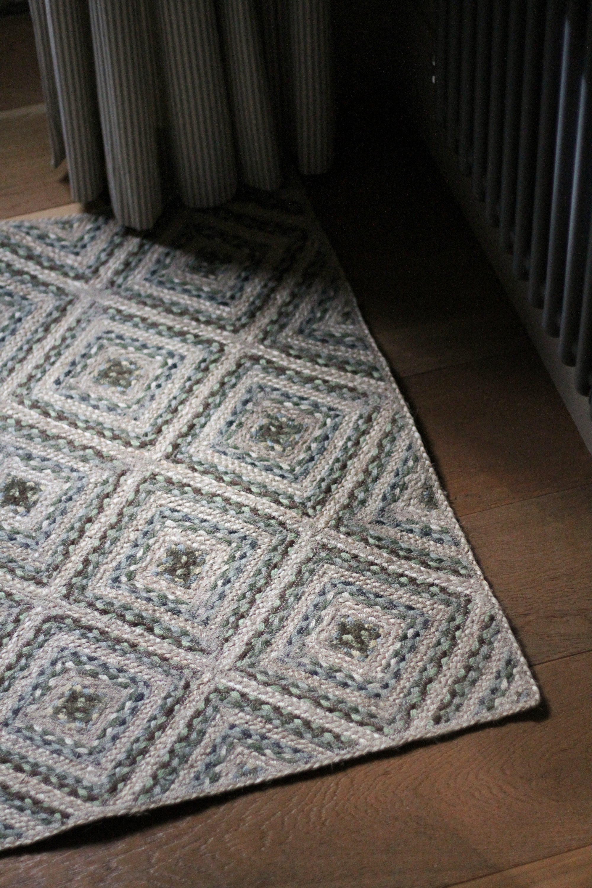 braided jute rug in a square patchwork design in shades of green