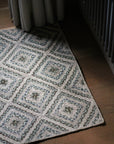 braided jute rug in a square patchwork design in shades of green