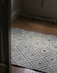 braided jute rug in a square patchwork design in shades of green