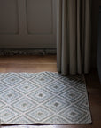 braided jute rug in a square patchwork design in shades of green
