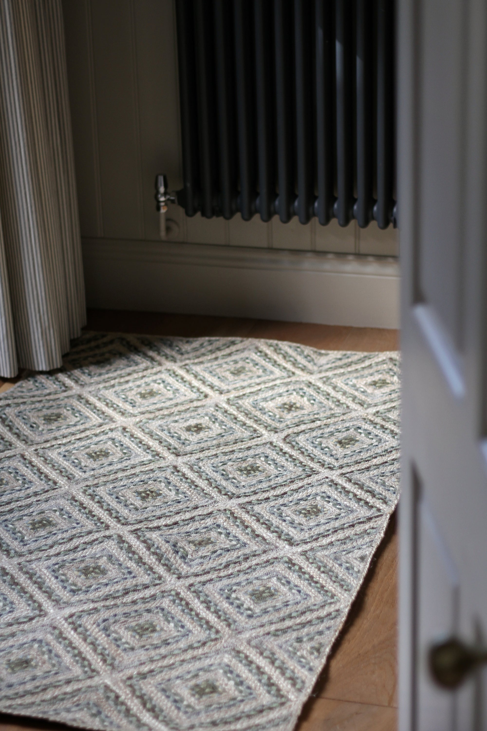 braided jute rug in a square patchwork design in shades of green