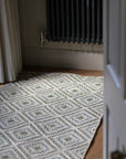braided jute rug in a square patchwork design in shades of green