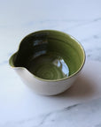 Green ceramic bowl on a marble surface