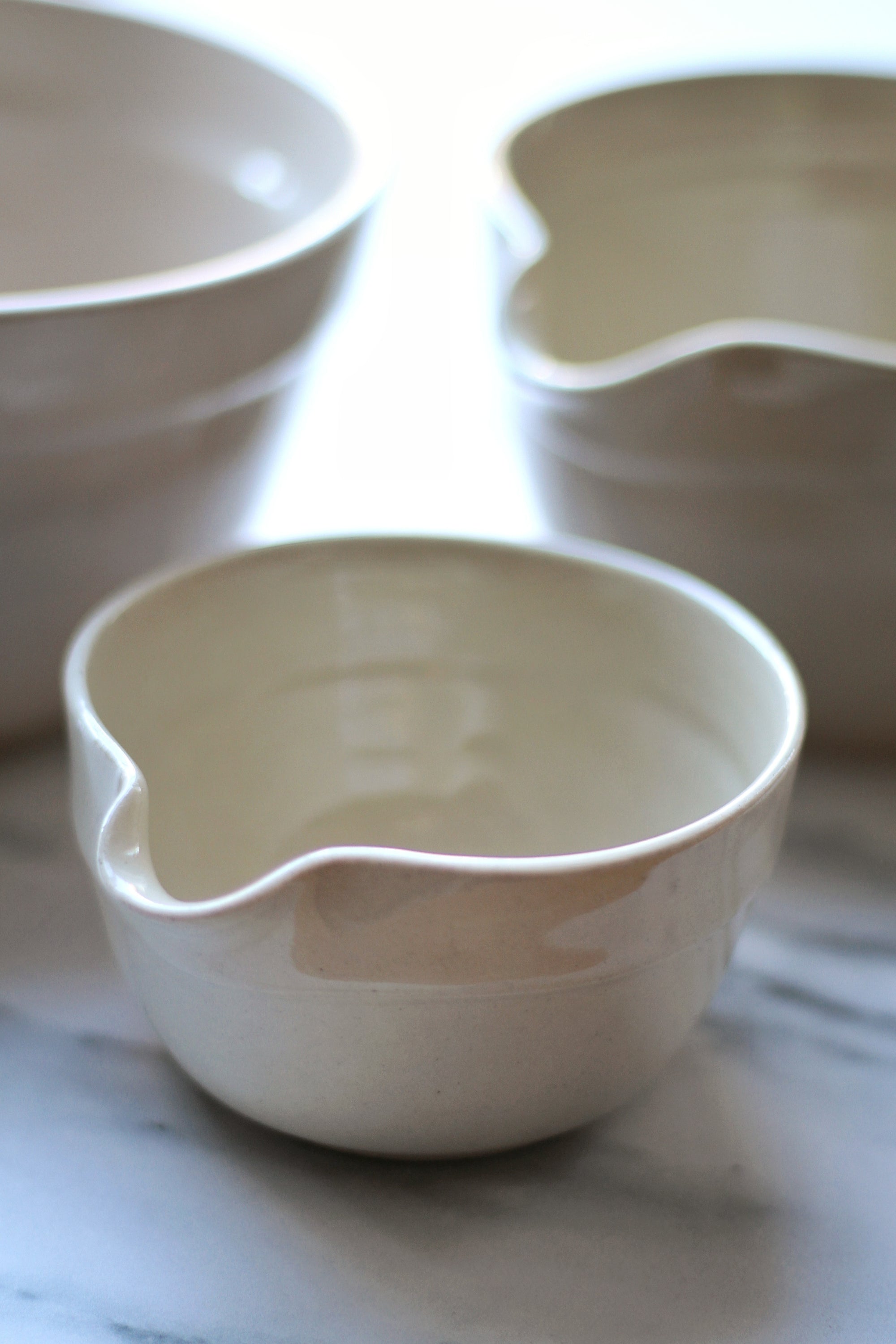 Three ceramic bowls of different shapes on a light background