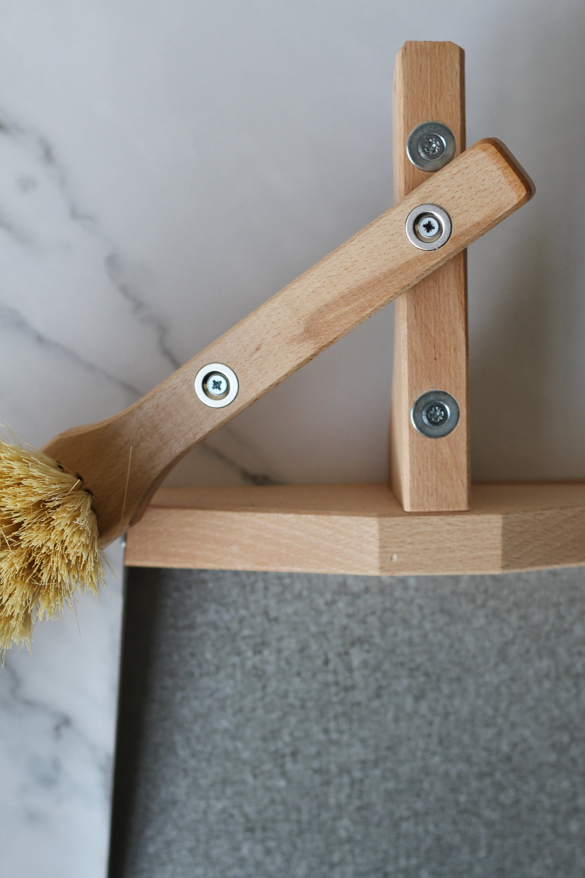 metal and wood dustpan and brush held together with magnets