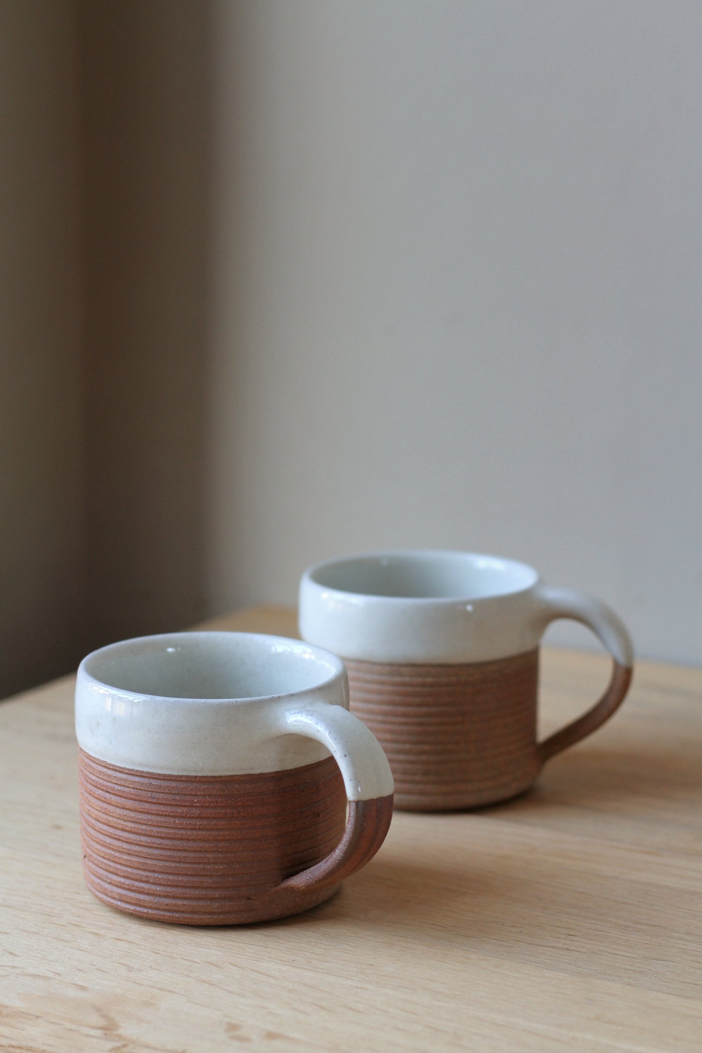 ribbed handmade terracotta coffee mug with a half white glaze rim