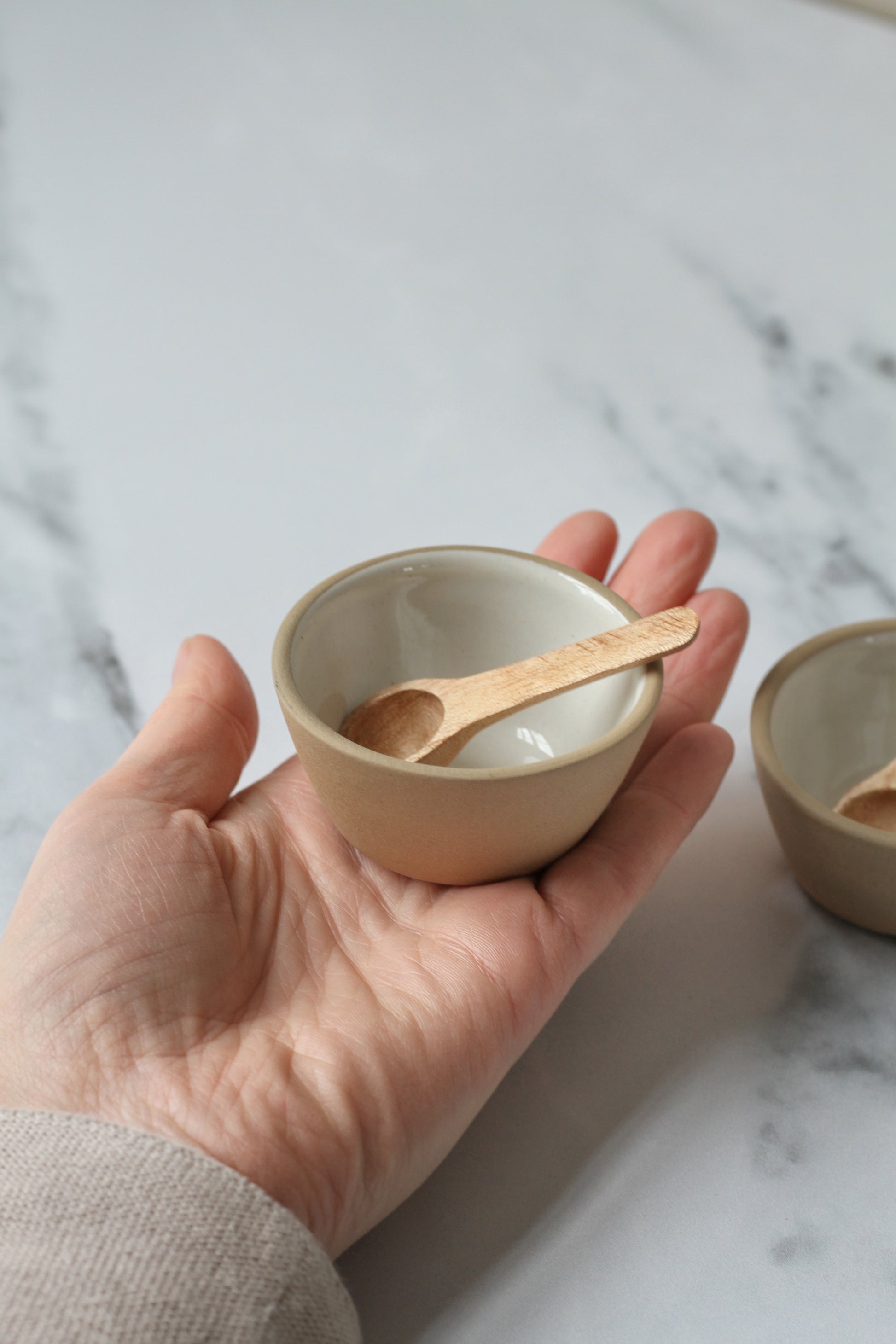pair of white pinch pots with wooden spoons