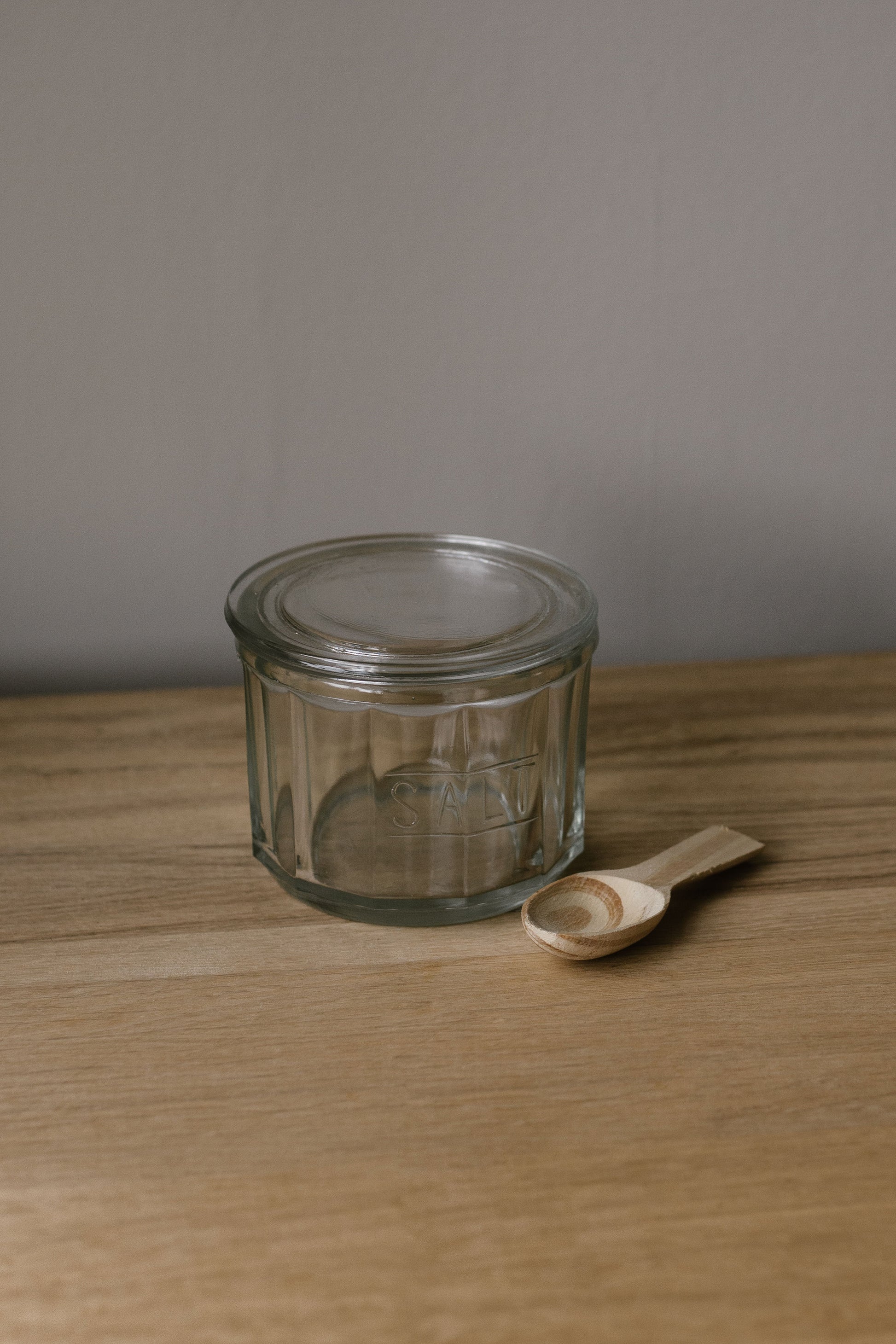 glass salt pot with lid and wooden spoon
